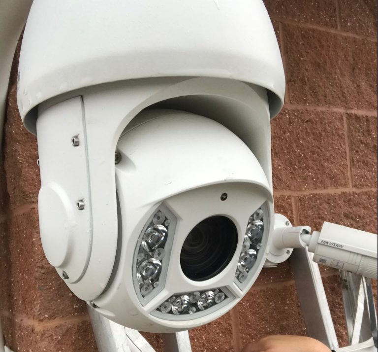 close up of business security ptz camera installed on brown brick building in Houston