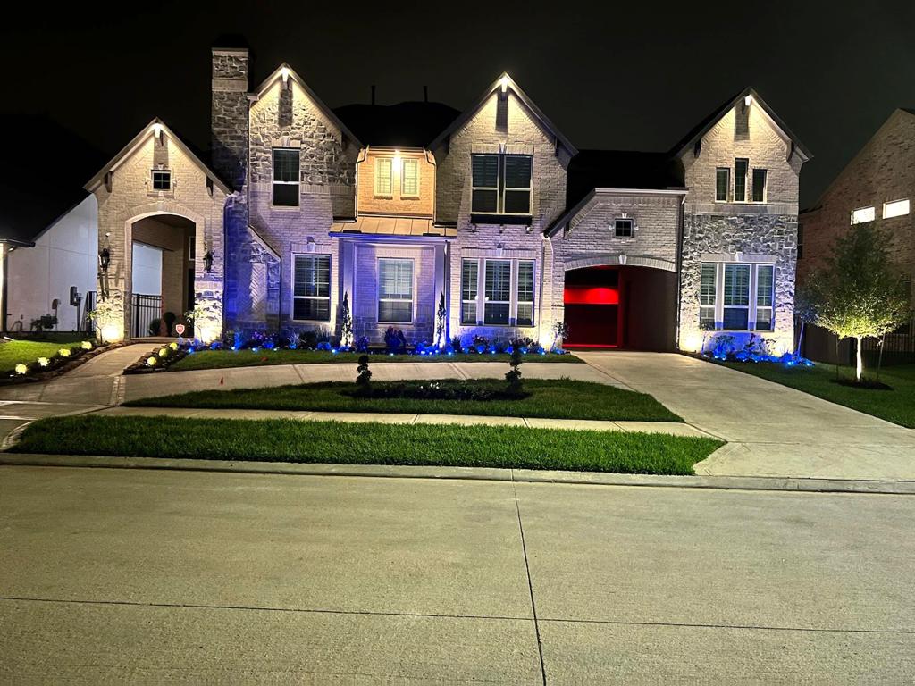 front view of a beautifully lit home with landscape lights front view in Missouri City combination of up lights and down lights